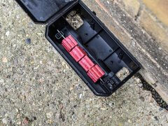 Rat bait station open with red rodent poison